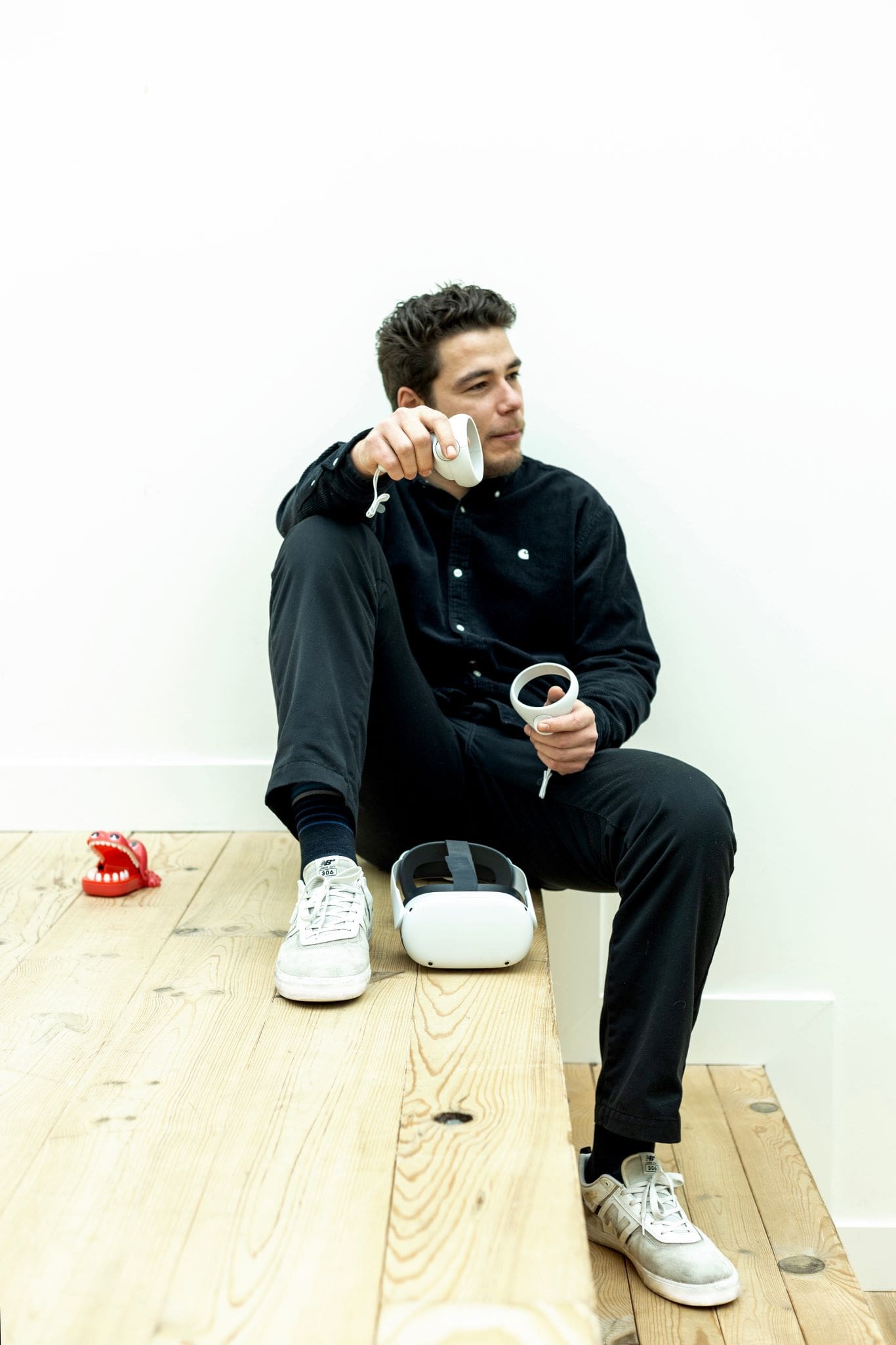 Afbeelding van Raphael Kolijn die op een trap zit met VR controllers in zijn handen